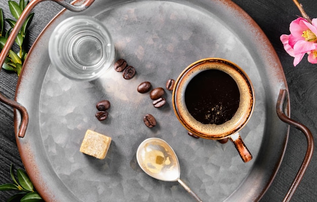 Espresso in Tasse auf Tablett mit Glas Wasser und Zucker Blick von oben Italienischer Kaffee zum Frühstück