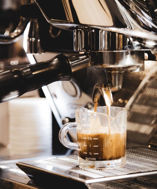 Espresso-Maschine, die einen Kaffee braucht Kaffee, der in Gläser in Kaffeehäusern gegossen wird Espresso, das aus der Kaffeemaschine gegossen wurde