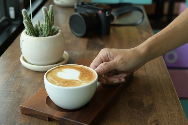 Espresso en taza de café con leche con fondo de mesa de madera marrón