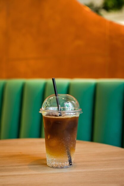 Espresso Tonic eiskaltes Erfrischungsgetränk in einem Glas zum Mitnehmen auf dem Tisch in einem Café