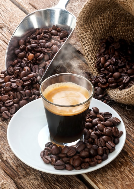Espressokaffee in der glasschale mit kaffeebohnen.
