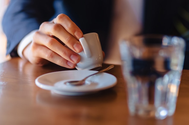 Espressokaffeetasse in der Hand der stilvollen Männer, Morgenkaffee am Café