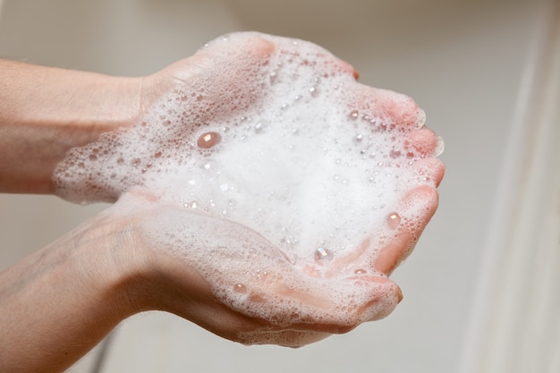 Espuma de sabão nas mãos femininas