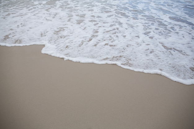 Foto espuma de surf do mar na areia do litoral