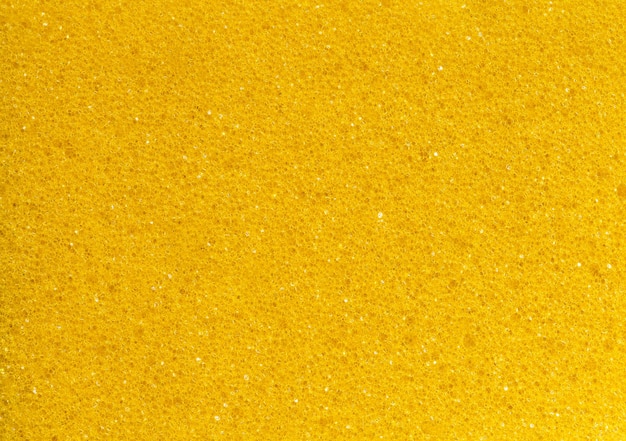 Espuma de goma amarilla esponja poros poligonales primer plano fondo papel tapiz patrón de textura uniforme