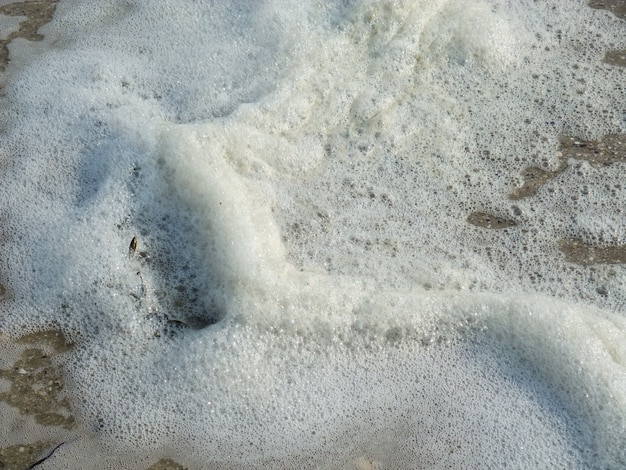 Espuma hecha por la ola en la playa.