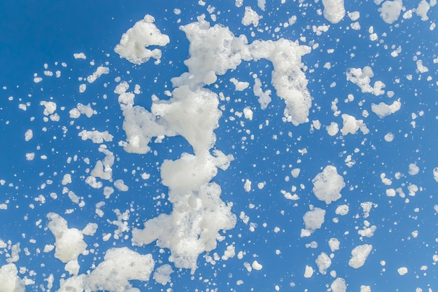 La espuma de jabón vuela desde un cañón contra el cielo