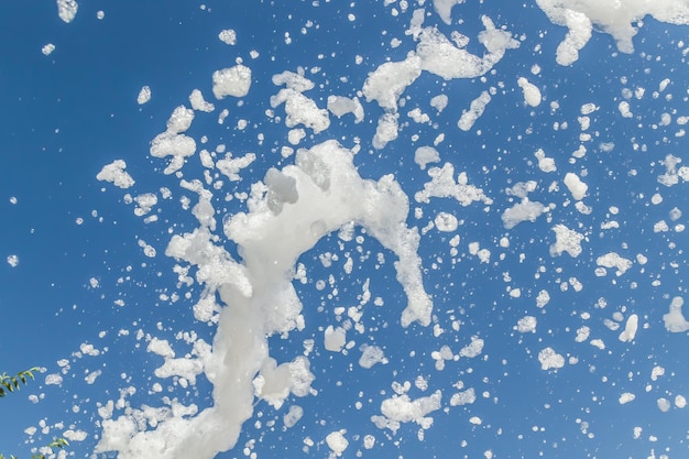 La espuma de jabón vuela desde un cañón contra el cielo