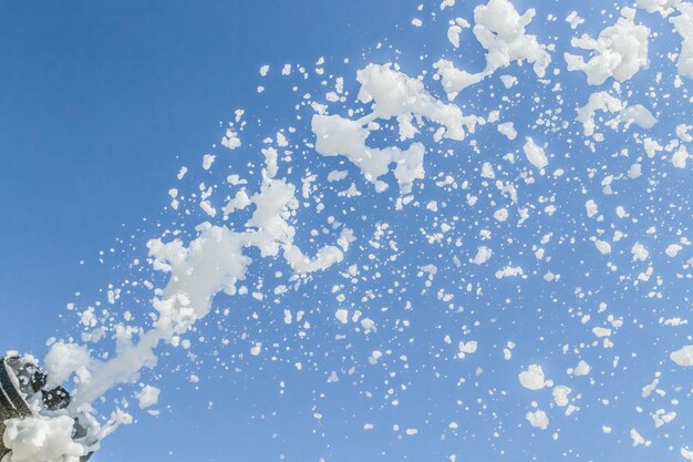 La espuma de jabón vuela desde un cañón contra el cielo