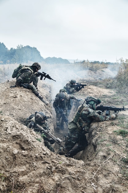 Esquadrão de paraquedistas franceses de elite do 1º Regimento de Pára-quedas de Infantaria da Marinha RPIMA em ação nas trincheiras inimigas cheias de fumaça de pólvora