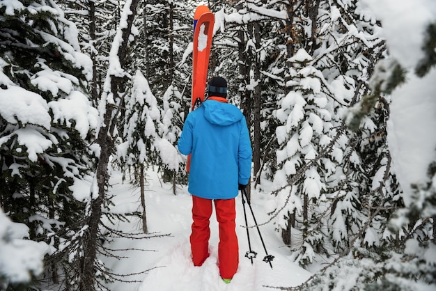 Esquiador andando com esqui nas montanhas cobertas de neve