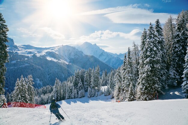 Esquiador bajando por la pendiente en la zona de esquí de Val Di Fassa en Italia