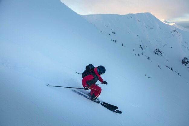 Esquiador curvo en la pendiente de freeride en las grandes montañas