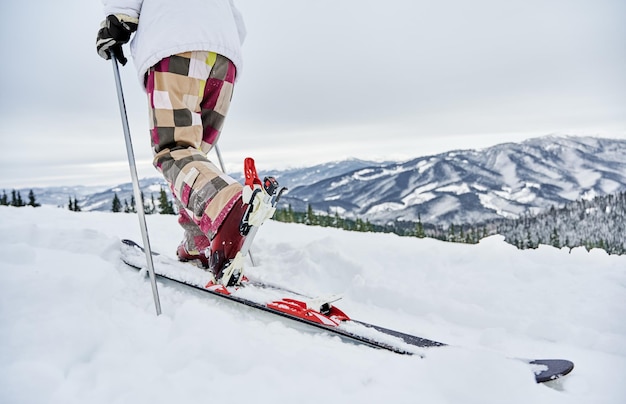 Esquiador de homem descendo a colina coberta de neve