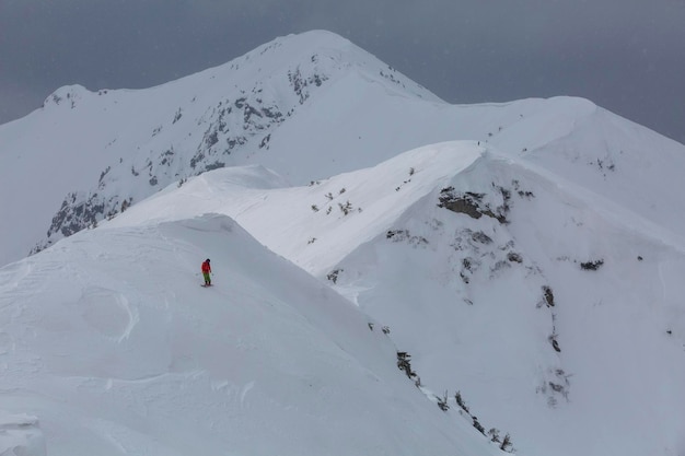 Un esquiador desciende por una empinada ladera congelada en las montañas