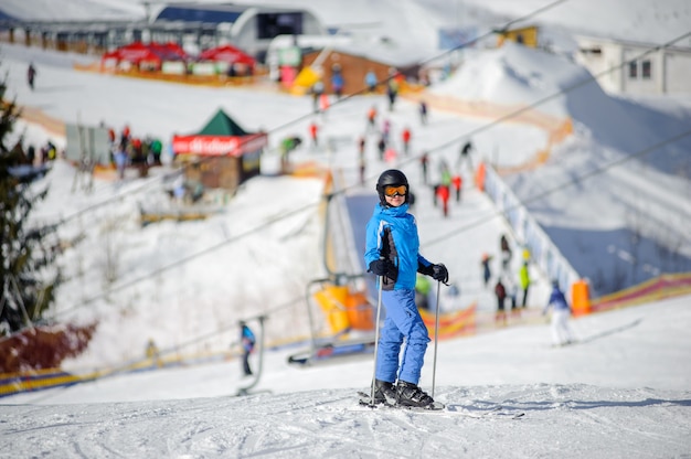 Esquiador feminino em uma pista de esqui em um dia ensolarado