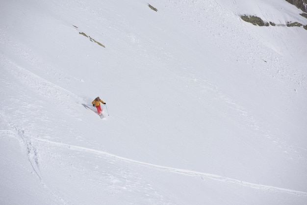 esquiador freeride esquiando en nieve polvo profunda