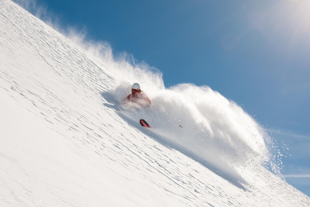 Esquiador de freeride yendo rápido cuesta abajo