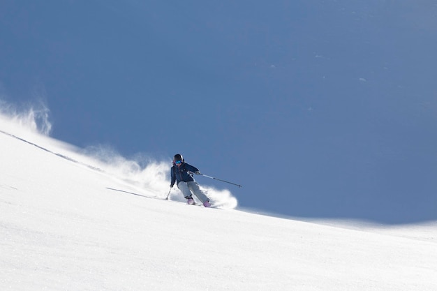 El esquiador hace un giro brusco y levanta una nube de nieve.