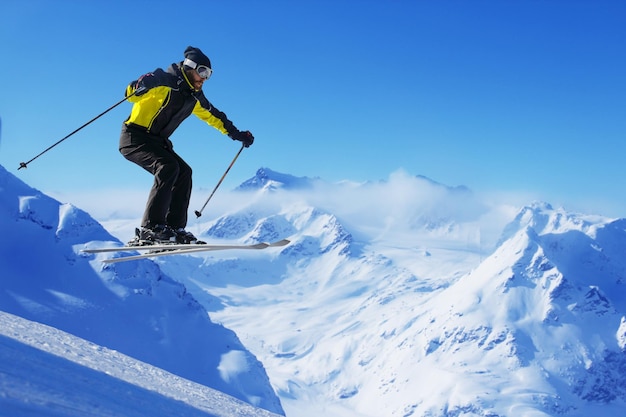 Esquiador de salto en salto con alta montaña alpina