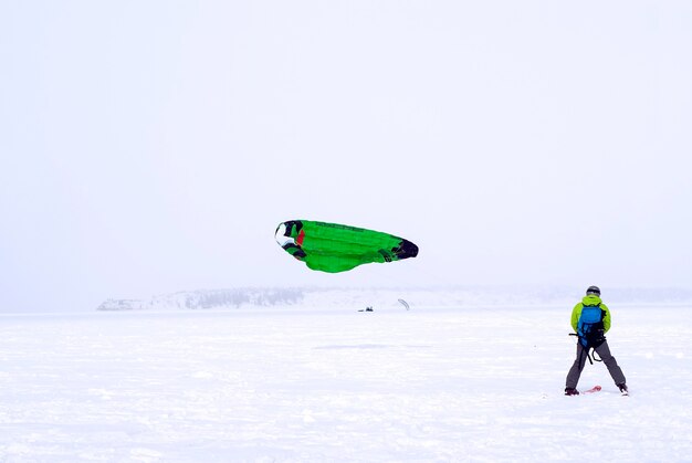 Esquiador-snowkiter atrapa el viento durante una nevada