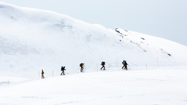 Foto esquiadores andando na neve cobriu cordilheiras