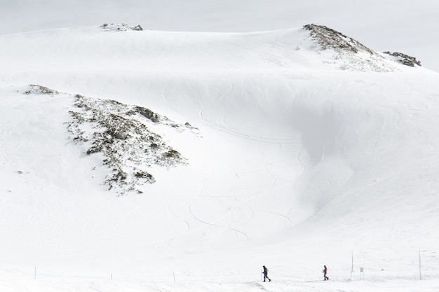 Foto esquiadores andando na neve cobriu cordilheiras