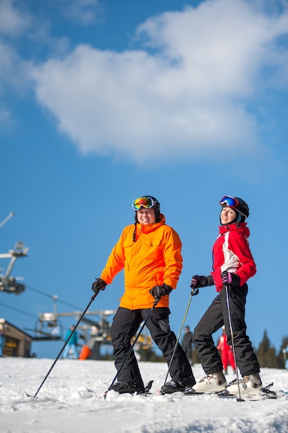 Esquiadores de homem e mulher com esquis no resort de inverno