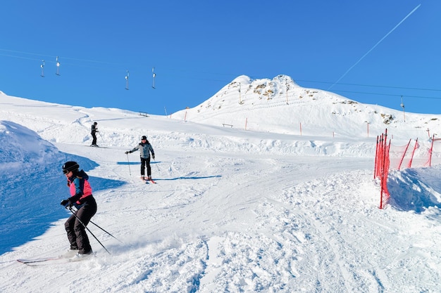 Esquiadores en la estación de esquí Hintertux Glacier en Zillertal en Tirol. Austria en invierno en los Alpes. Hombres y mujeres en las montañas alpinas con nieve. Diversión cuesta abajo. Cielo azul, laderas blancas. Hintertuxer Gletscher