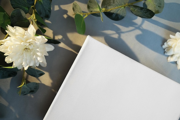 Esquina del marco de lienzo en blanco con flores blancas