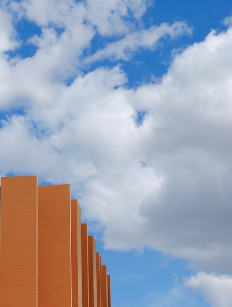 Foto esquina mínima de la fachada del edificio moderno contra el cielo azul nublado arquitectura minimalista detalle fondo urbano mínimo foto vertical