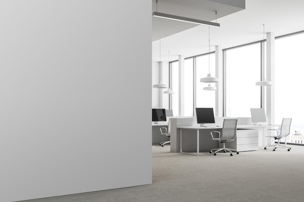 Esquina de oficina moderna con paredes blancas, ventanas tipo loft, piso de concreto y filas de mesas de computadora. Una pared blanca en blanco. maqueta de renderizado 3d