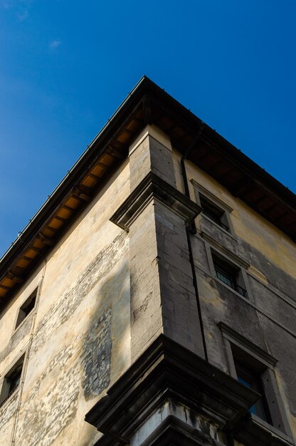 Esquina de una vieja casa en mal estado contra el cielo