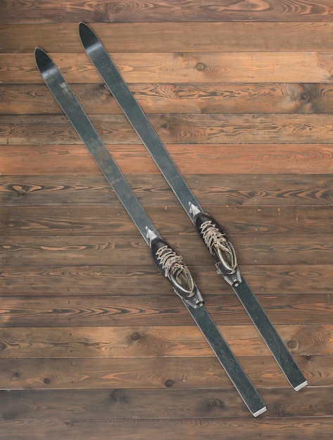 esquis alpinos com botas de esqui no chão de madeira