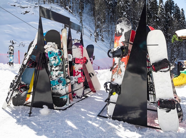 Esquís alpinos y equipos de snowboard apoyado en el portaesquís en la estación de esquí de invierno