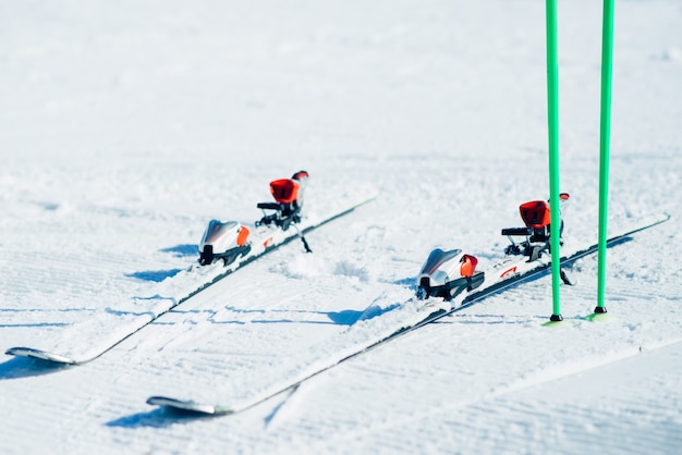 Esquís y bastones que sobresalen del primer plano de la nieve, nadie. Concepto de deporte activo de invierno. Equipo de esquí de montaña