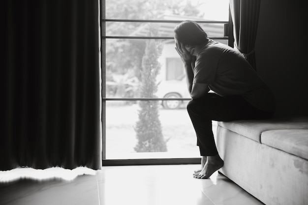 Esquizofrenia com solidão e tristeza no conceito de depressão de saúde mental Mulher deprimida sentada no sofá em casa com quarto escuro sentindo-se miserável As mulheres estão deprimidas com medo e infelizes