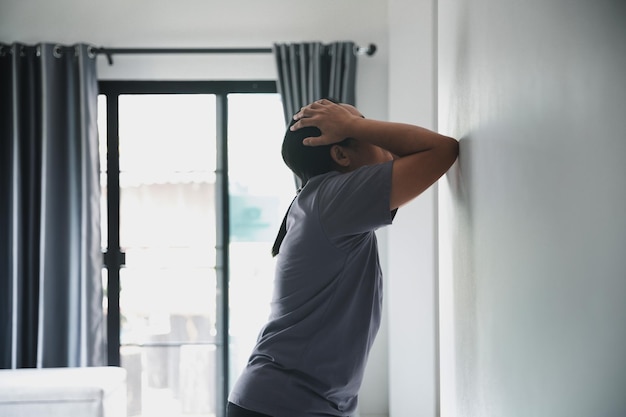 Foto esquizofrenia con soledad y tristeza en el concepto de depresión de salud mental mujer deprimida de pie en contra de un cuarto oscuro sintiéndose miserable en casa las mujeres están deprimidas temerosas e infelices