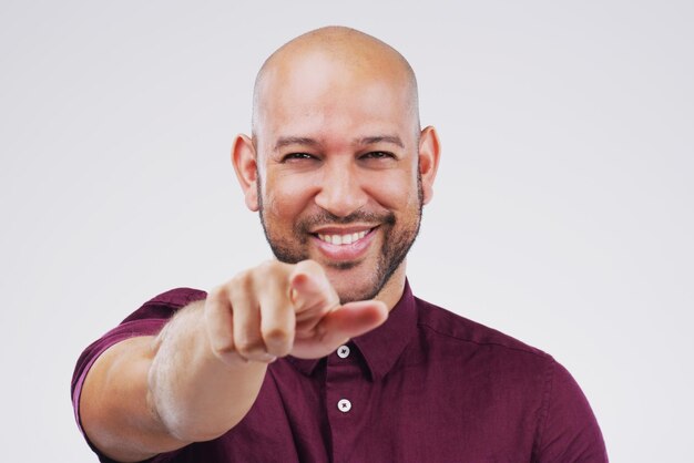 Foto essa é a maneira de fazê-lo campeão retrato de um jovem bonito apontando para a câmera contra um fundo cinza