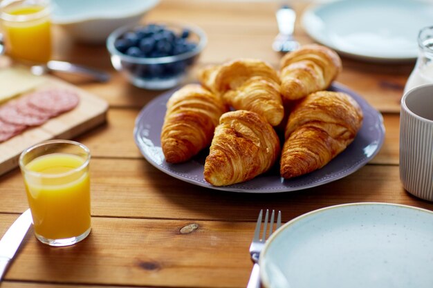 Foto essen backen und essen konzept platte von croissants auf einem holztisch beim frühstück