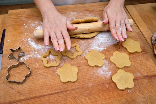 Foto essen; frau backt selbstgemachte kekse auf dem holztisch einer küche