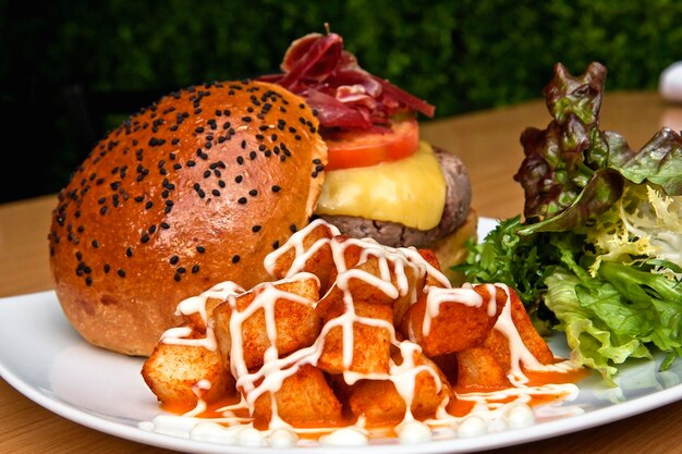 essen gegrilltes rindfleisch burger serrano-schinken und pommes frites holztisch