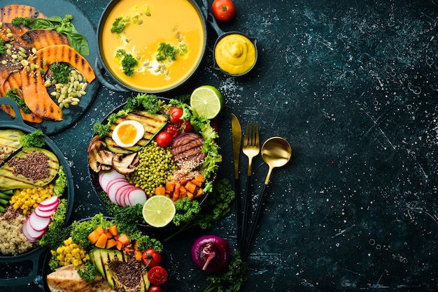 Essen Hintergrund Pasta Huhn Kürbis Salat Fleisch Pilze Gemüse Auf einem schwarzen Stein Hintergrund Ansicht von oben Freier Platz für Text