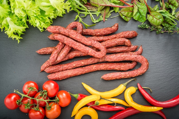 Essen Hintergrund. Snackstockwürste auf einem Holztisch