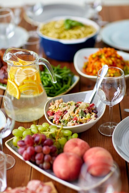 Foto essen kulinarisches und essen konzept geräucherte hühner salat krug mit orangenwasser und früchten auf einem holztisch