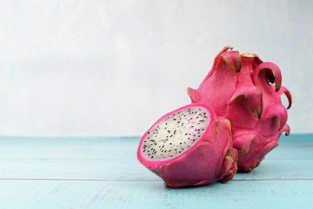 Essen reife tropische Drachenfrucht rosa und eine Hälfte