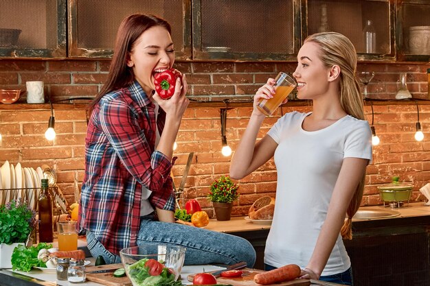 Foto essen sie gut, um gut zu sein, junge freundinnen, die in der modernen küche gemeinsam gesunde mahlzeiten zubereiten