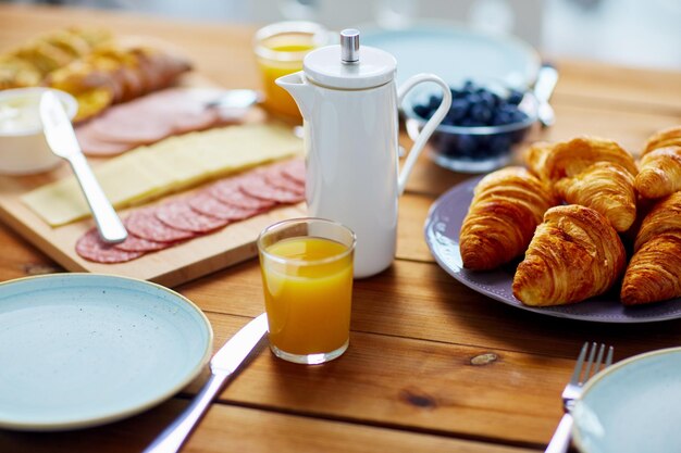 Foto essen und essen konzept kaffee topf und glas orangensaft auf dem servierten holztisch beim frühstück