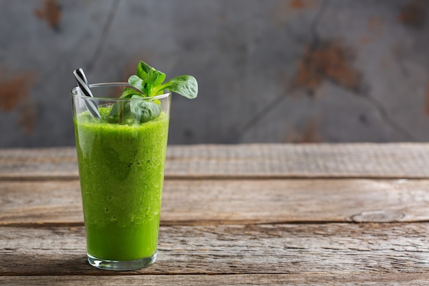 Essen und Trinken, gesunde Ernährung und Ernährung, Lebensstil, veganes, alkalisches, vegetarisches Konzept. Grüner Smoothie mit Bio-Zutaten, Gemüse auf einem Holzküchentisch. Raumhintergrund kopieren