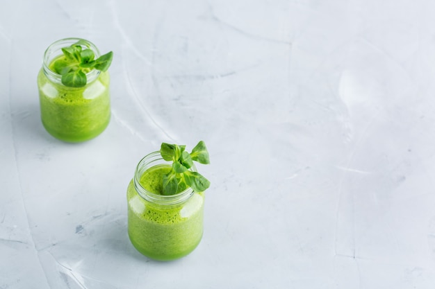 Essen und Trinken, gesunde Ernährung und Ernährung, Lebensstil, veganes, alkalisches, vegetarisches Konzept. Grüner Smoothie mit Bio-Zutaten, Gemüse auf einem modernen Küchentisch. Raumhintergrund kopieren